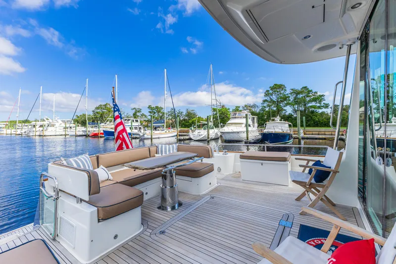 Sandcrab Yacht Photos Pics Luxurious 2018 Sabre 66 Dirigo yacht deck with seating, docked at marina.