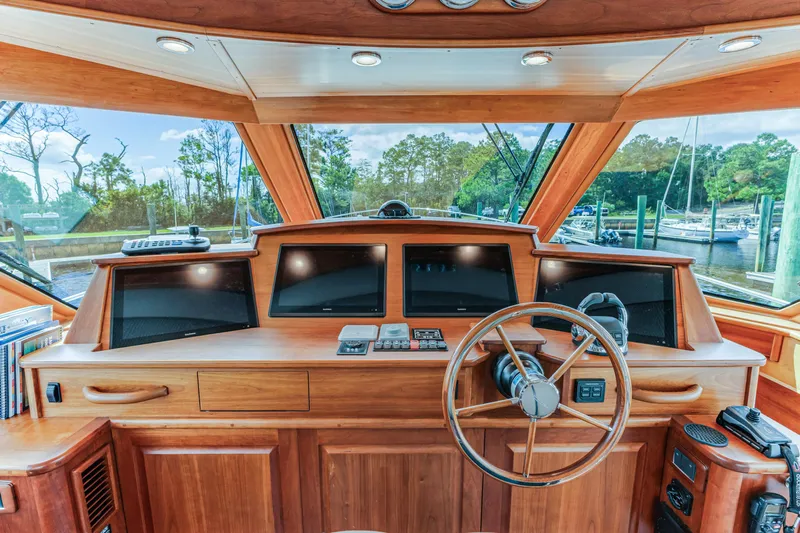 Sandcrab Yacht Photos Pics 2018 Sabre 66 Dirigo helm with wooden dashboard and steering wheel, featuring multiple screens.