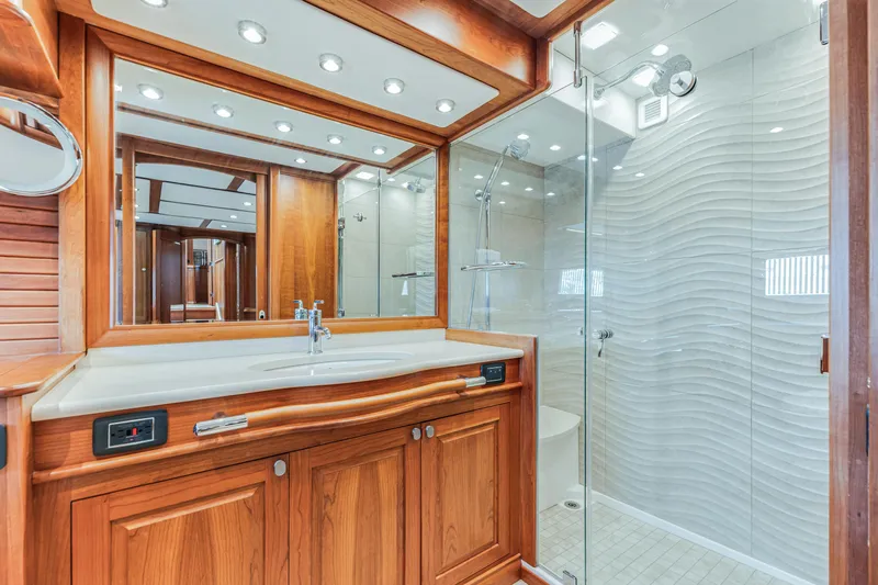 Sandcrab Yacht Photos Pics Luxurious bathroom in 2018 Sabre 66 Dirigo yacht with wooden cabinetry and glass shower.