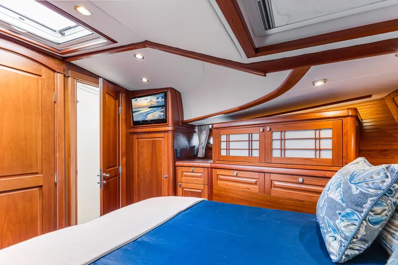 Sandcrab Yacht Photos Pics Luxurious interior of 2018 Sabre 66 Dirigo yacht with wooden cabinetry and cozy bedding.