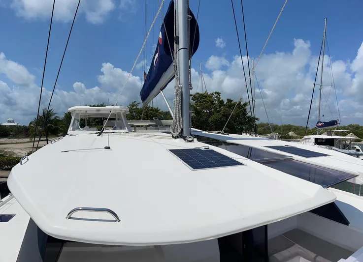 Seventeen Yacht Photos Pics 2020 Leopard 50 catamaran with solar panels and sails, docked at a marina.