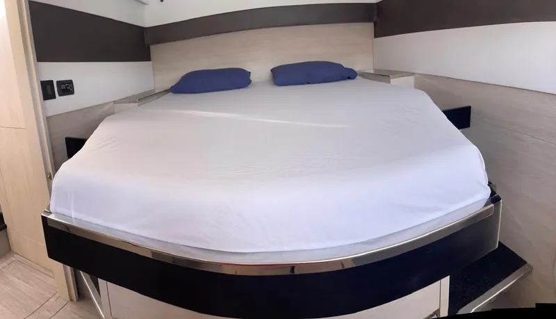 Seventeen Yacht Photos Pics Leopard 50 yacht 2020 model bedroom with a neatly made bed and blue pillows.