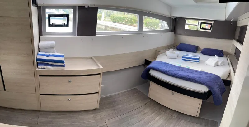 Seventeen Yacht Photos Pics Modern bedroom interior of Leopard 50 yacht, 2020 model, with bed, drawers, and windows.