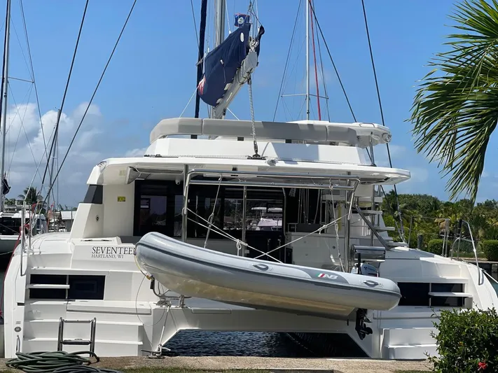 Seventeen Yacht Photos Pics 2020 Leopard 50 catamaran with dinghy, docked at marina under clear blue sky.