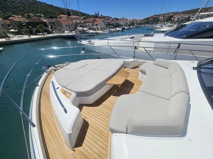  Yacht Photos Pics Luxurious 2020 Princess F62 yacht with spacious deck seating in a scenic marina.
