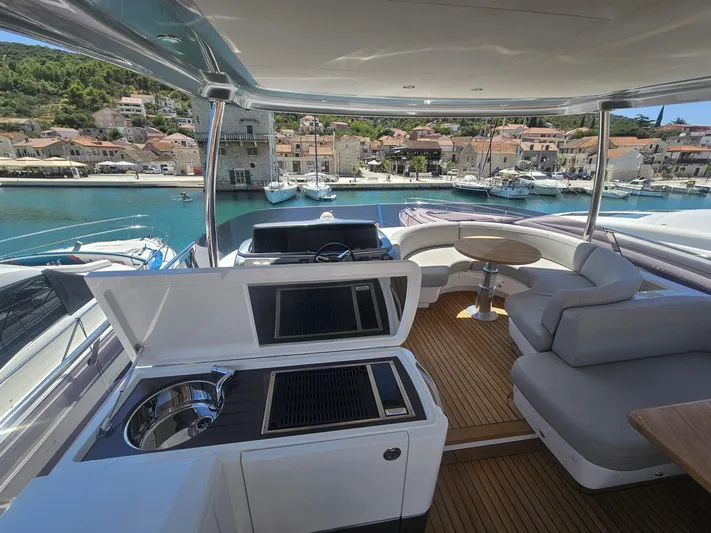  Yacht Photos Pics Luxurious 2020 Princess F62 yacht interior with kitchenette and seating, docked in scenic harbor.