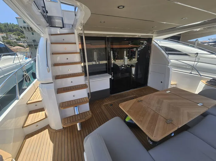  Yacht Photos Pics Luxurious 2020 Princess F62 yacht deck with wooden stairs and seating area.