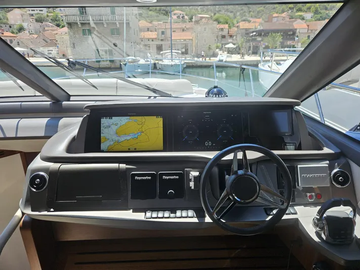  Yacht Photos Pics Helm of 2020 Princess F62 yacht with navigation screens and steering wheel.