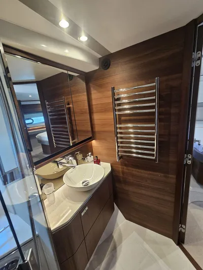 Yacht Photos Pics Luxurious bathroom in 2020 Princess F62 yacht with modern fixtures and wood paneling.