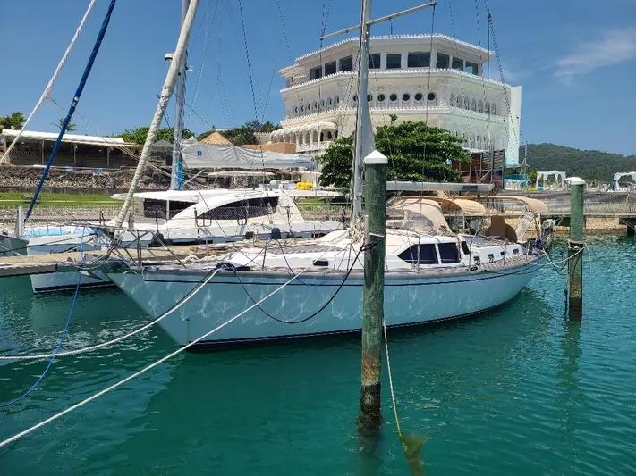 Taita I Yacht Photos Pics Sailboat Comet 54 DH 2001 docked in marina with modern building in background.