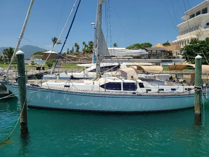 Taita I Yacht Photos Pics Sailboat Comet 54 DH 2001 docked in a sunny marina with clear blue water.
