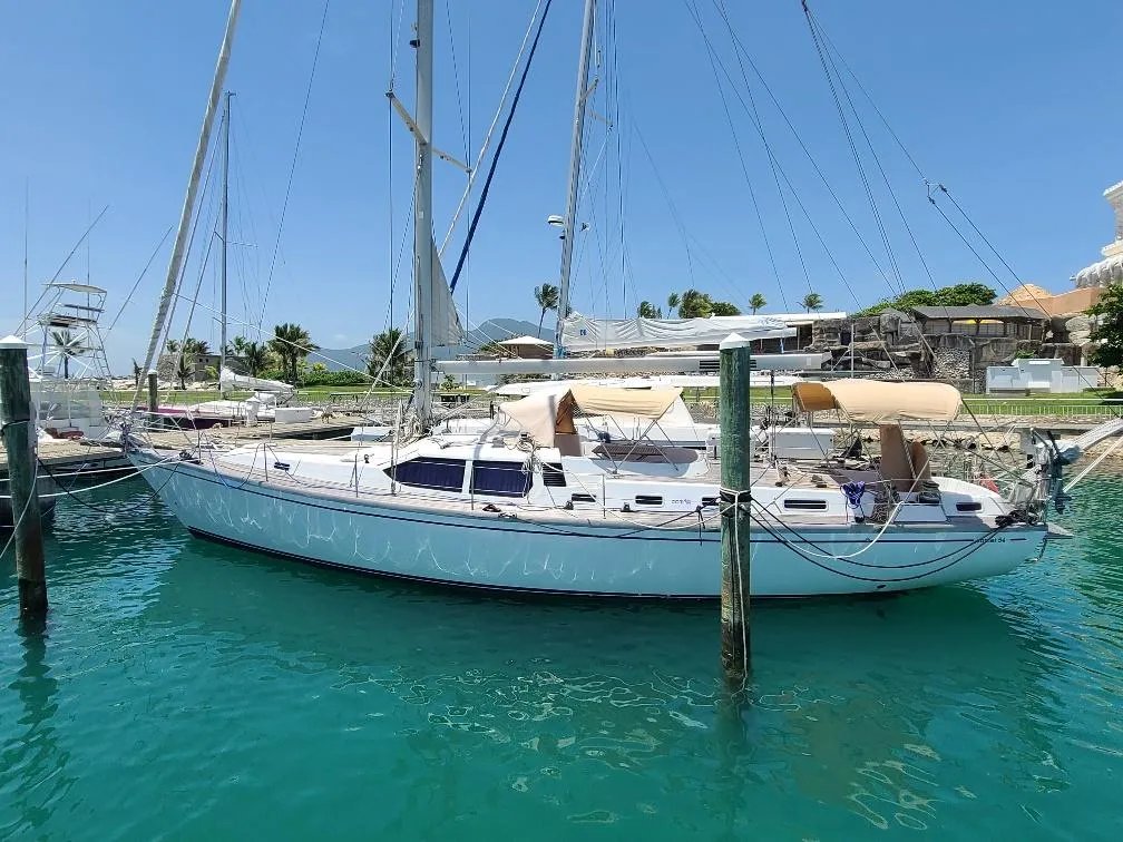 Sailboat Comet 54 DH 2001 docked in clear turquoise water, sunny day.