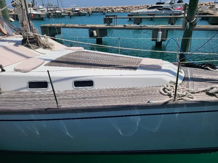 Taita I Yacht Photos Pics Sailboat Comet 54 DH 2001 docked at marina with clear blue water.