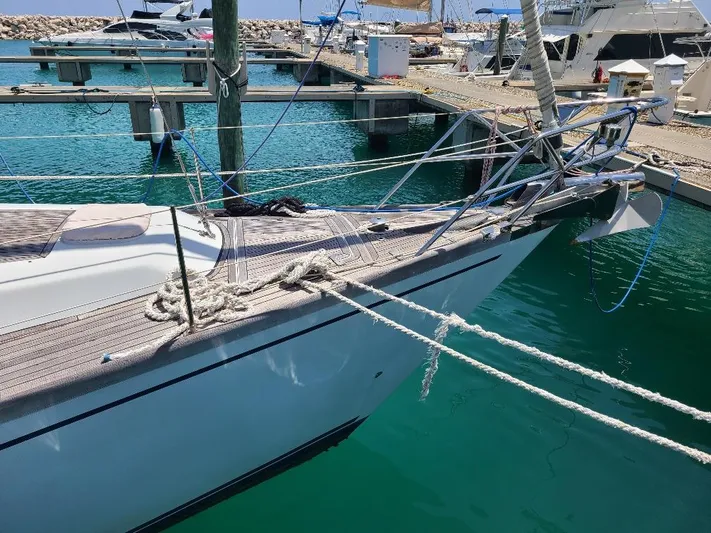 Taita I Yacht Photos Pics Sailboat Comet 54 DH, 2001 model, docked in a marina with clear blue water.