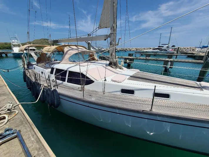 Taita I Yacht Photos Pics Sailboat Comet 54 DH 2001 docked in marina with clear blue water.