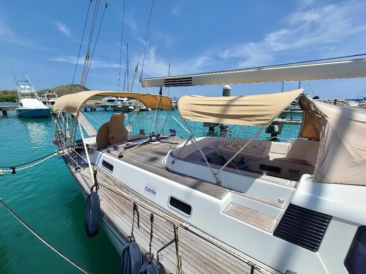 Taita I Yacht Photos Pics Sailing yacht Comet 54 DH, 2001 model, docked in a marina with clear blue water.