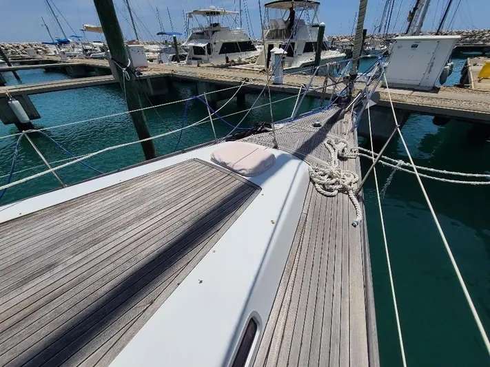 Taita I Yacht Photos Pics Sailboat deck of 2001 Comet 54 DH in marina, with clear blue water and docked boats.
