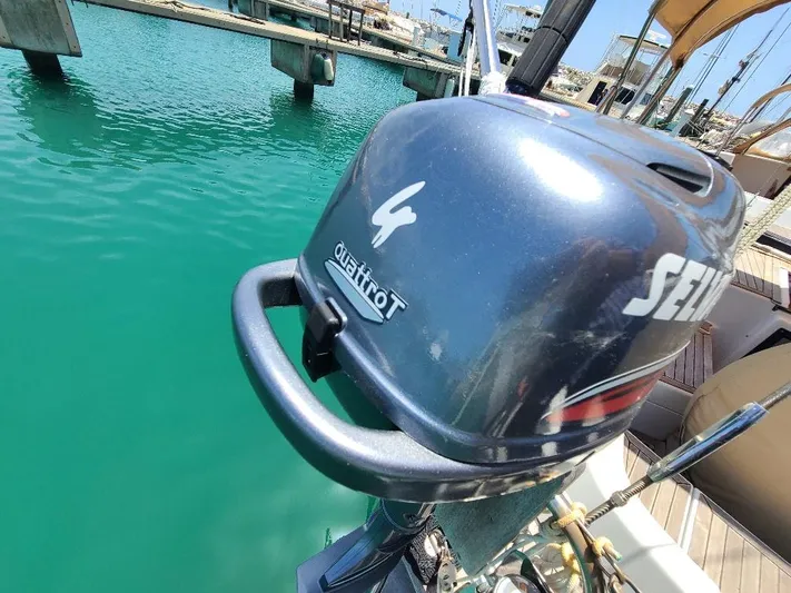 Taita I Yacht Photos Pics Outboard motor on a boat docked in clear turquoise water, Comet 54 DH, 2001 model.