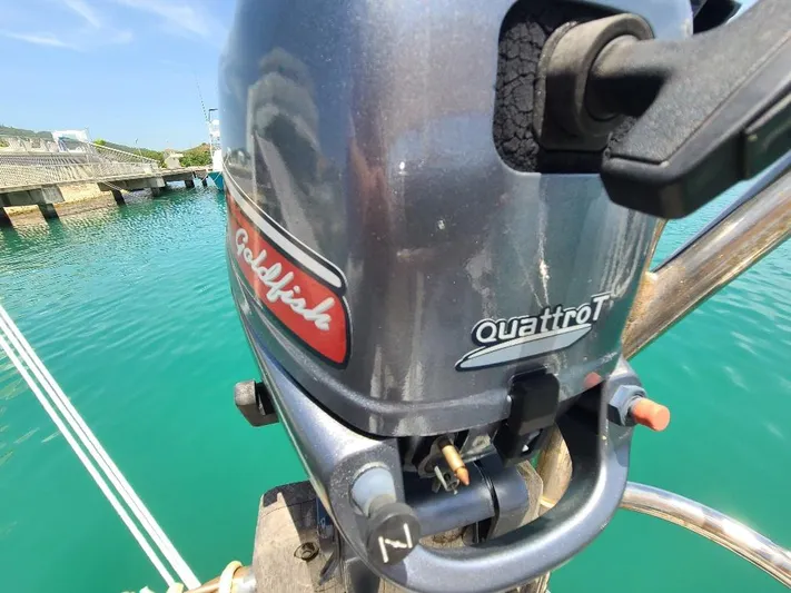 Taita I Yacht Photos Pics Outboard motor on a boat, labeled "Goldfish Quattro T," dockside view.