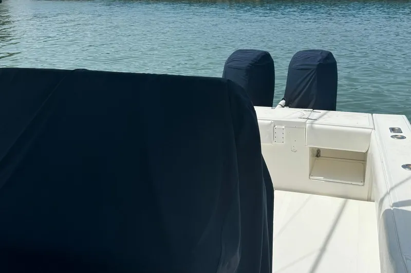 Reel Lucky Yacht Photos Pics 2006 Venture 34 Open boat with covered engines on calm water.