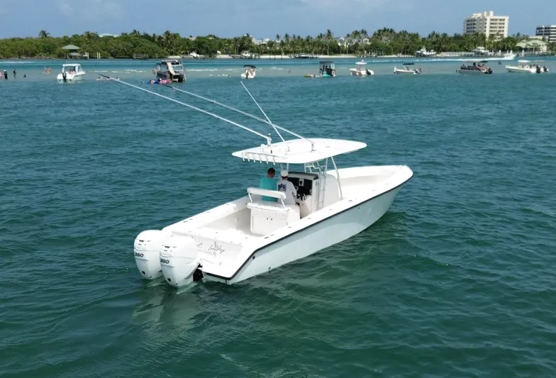 Reel Lucky Yacht Photos Pics 2006 Venture 34 Open boat on calm blue water, with dual engines and fishing rods.