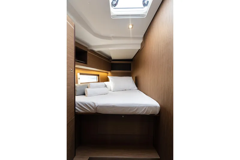  Yacht Photos Pics Cozy cabin interior of 2020 Beneteau Oceanis 46.1 yacht with bed and wooden finish.