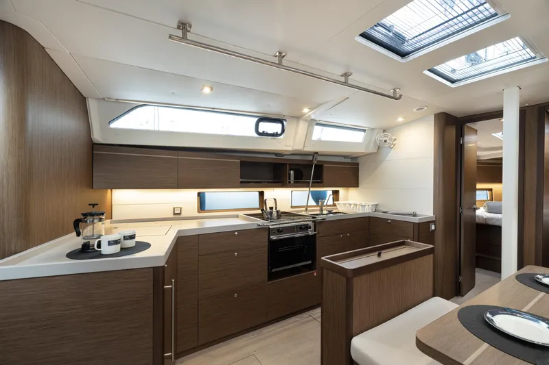  Yacht Photos Pics Modern kitchen interior of 2020 Beneteau Oceanis 46.1 yacht, featuring sleek wood cabinetry.