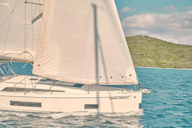  Yacht Photos Pics 2020 Beneteau Oceanis 46.1 sailing near a lush island under clear skies.