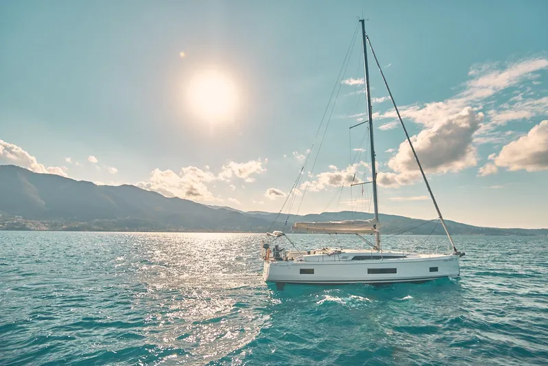  Yacht Photos Pics 2020 Beneteau Oceanis 46.1 sailing on sunny ocean with mountains in background.