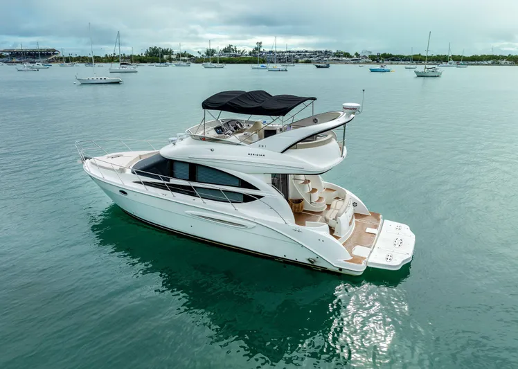 Crescendo Yacht Photos Pics 2012 Meridian Sedan Bridge yacht on calm waters with other boats in the background.