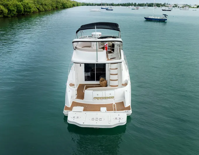 Crescendo Yacht Photos Pics 2012 Meridian Sedan Bridge yacht on calm water with lush green shoreline.