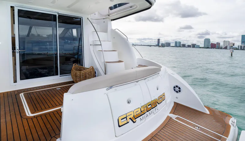 Crescendo Yacht Photos Pics 2012 Meridian Sedan Bridge yacht with wooden deck and city skyline in the background.