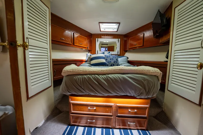  Yacht Photos Pics Cozy bedroom in 1984 Ocean Yachts 46, featuring wood accents and nautical decor.