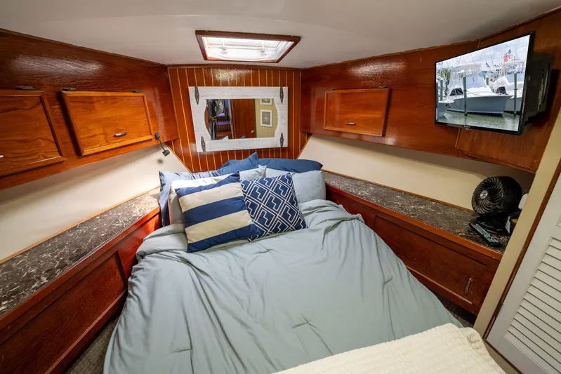  Yacht Photos Pics Cozy cabin interior of 1984 Ocean Yachts 46 with wood paneling and comfortable bedding.