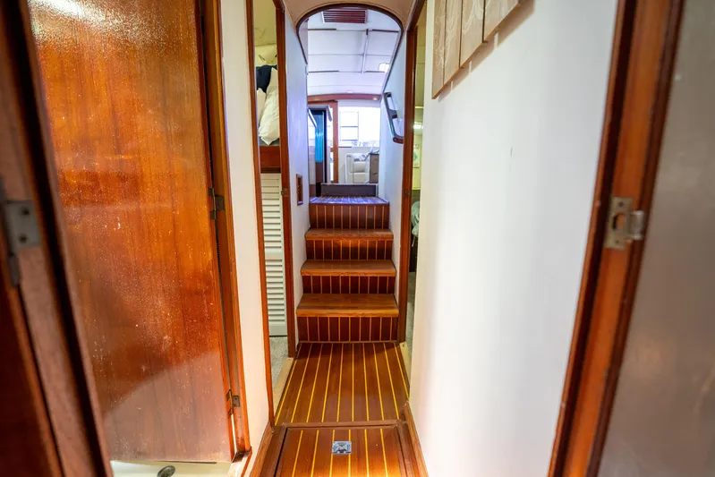  Yacht Photos Pics Interior hallway of a 1984 Ocean Yachts 46, featuring wooden steps and paneling.