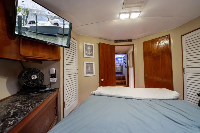  Yacht Photos Pics Interior of 1984 Ocean Yachts 46, featuring a cozy bedroom with TV and wooden accents.