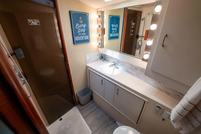  Yacht Photos Pics 1984 Ocean Yachts 46 bathroom with vanity, mirror, and shower, featuring nautical decor.