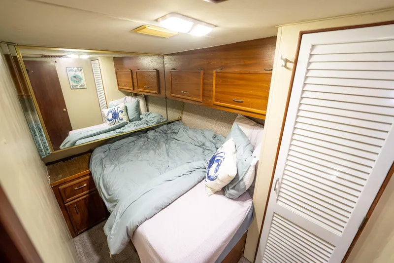  Yacht Photos Pics Cozy bedroom in 1984 Ocean Yachts 46, featuring wood cabinets and nautical-themed decor.