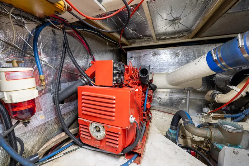  Yacht Photos Pics Engine room of 1984 Ocean Yachts 46, featuring red machinery and insulated walls.
