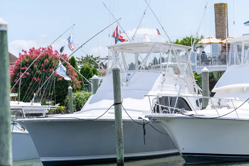  Yacht Photos Pics 1984 Ocean Yachts 46 docked, surrounded by lush greenery and vibrant flags.