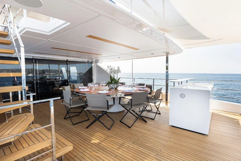 Haiami Yacht Photos Pics Luxurious 2022 Custom Line Navetta 33 yacht deck with dining area and ocean view.