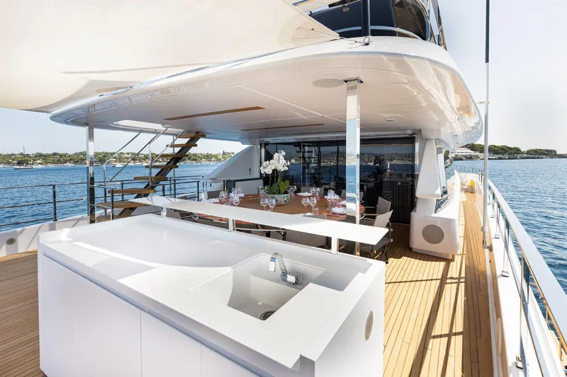 Haiami Yacht Photos Pics Luxurious 2022 Custom Line Navetta 33 yacht deck with dining area and ocean view.