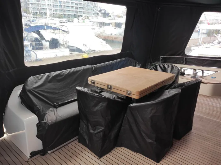  Yacht Photos Pics 2023 Cranchi Sessantasette 67 yacht interior with covered seating and table.