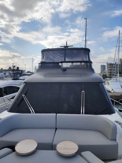  Yacht Photos Pics 2023 Cranchi Sessantasette 67 yacht with sleek design, docked under a partly cloudy sky.