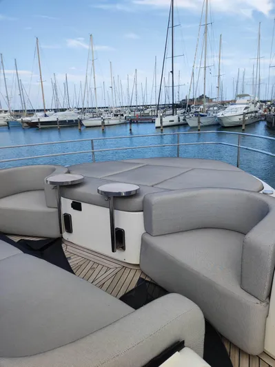  Yacht Photos Pics Luxurious 2023 Cranchi Sessantasette 67 yacht with elegant seating, docked in a marina.