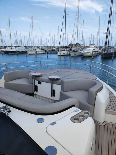  Yacht Photos Pics 2023 Cranchi Sessantasette 67 yacht with elegant seating, docked in a marina.