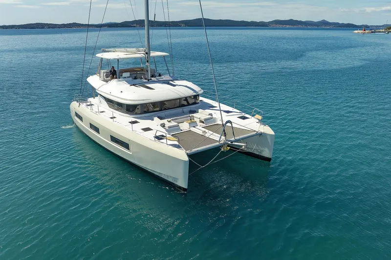 Saliska Yacht Photos Pics 2023 Lagoon 55 catamaran sailing on clear blue waters.