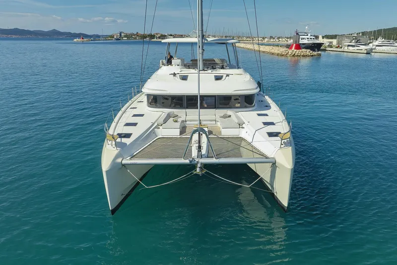 Saliska Yacht Photos Pics 2023 Lagoon 55 catamaran docked in clear blue water, front view.