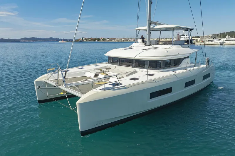 Saliska Yacht Photos Pics 2023 Lagoon 55 catamaran sailing on clear blue water.