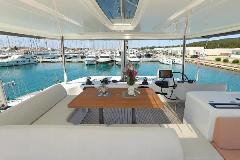Saliska Yacht Photos Pics Luxurious Lagoon 55 yacht interior with elegant seating, wooden table, and marina view, 2023 model.